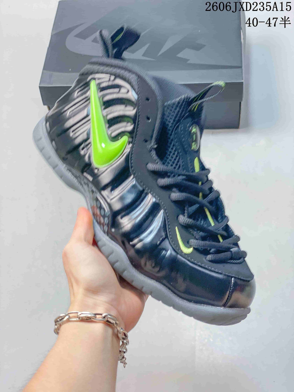 Angled side view of the dark Foamposite One shoe with a bright green side detail and gray outsole.