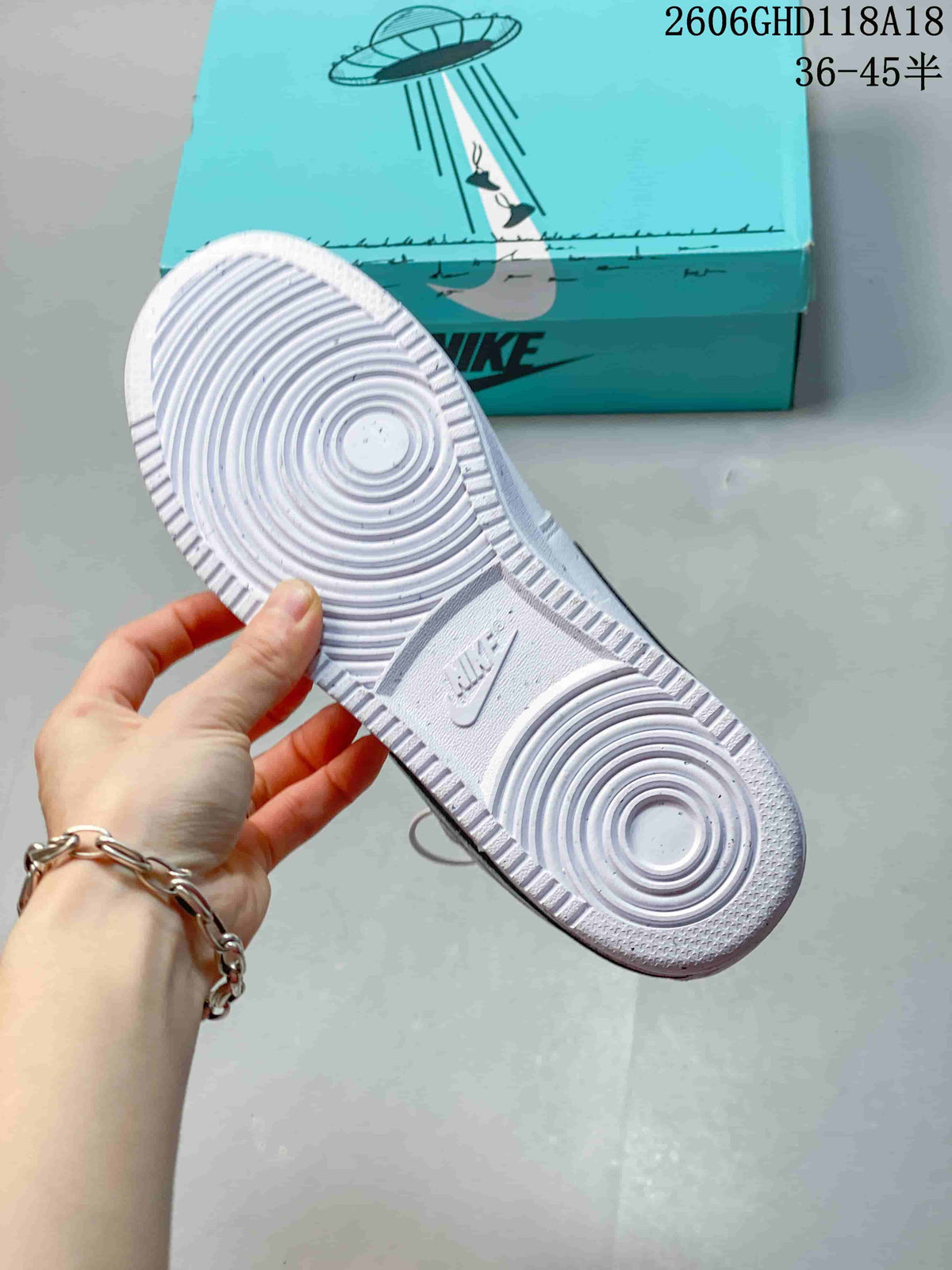 Underside of a white sneaker showing a circular-pattern outsole.