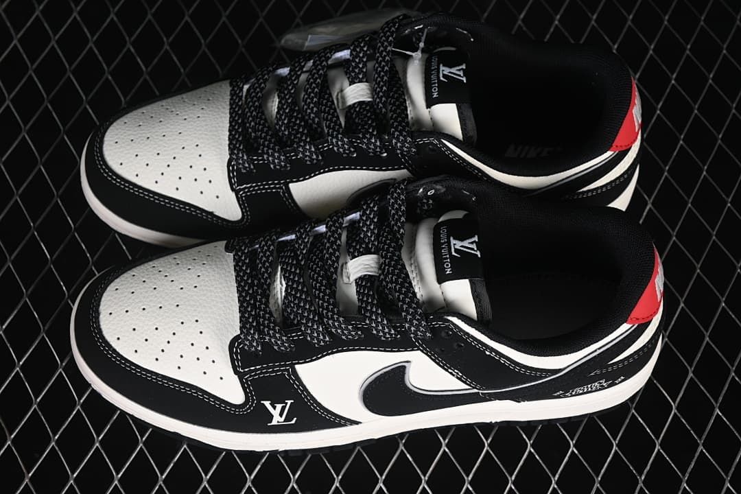 Top view of a pair of black and white low-top sneakers with patterned laces and red heel accents
