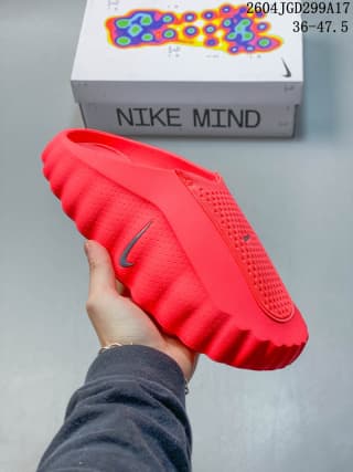 Angled underside view of the red Nike Mind slide with a visible Nike Swoosh and rounded outsole edges.