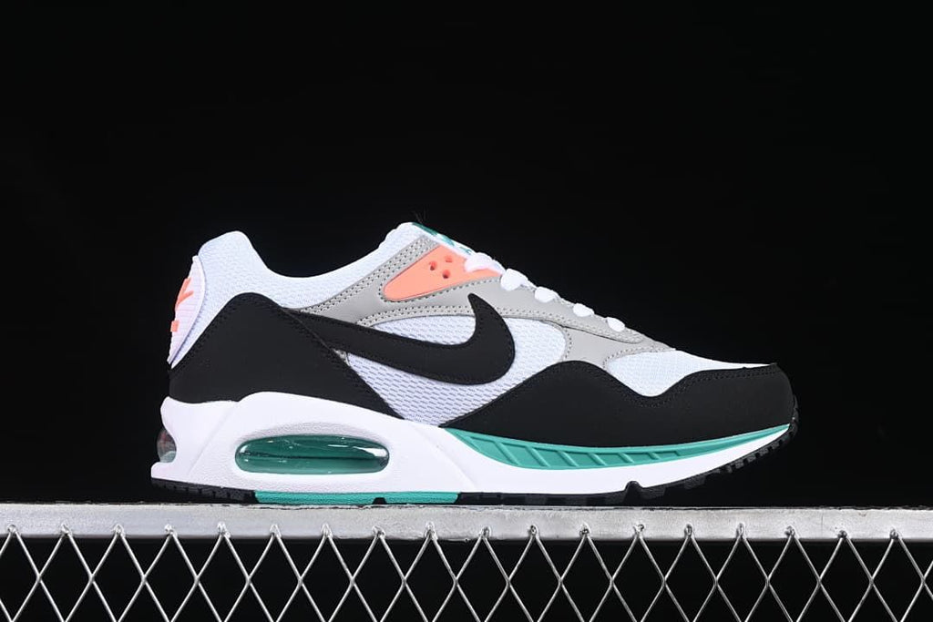 Side profile showing the black Swoosh, white upper, grey overlays, teal accents, and heel air unit.