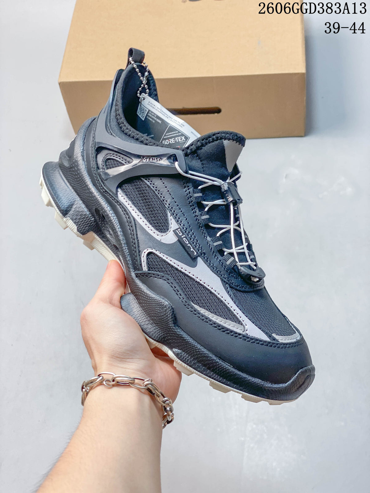Angled view of the navy and gray sneaker with cord-style closure and visible GORE-TEX tag.