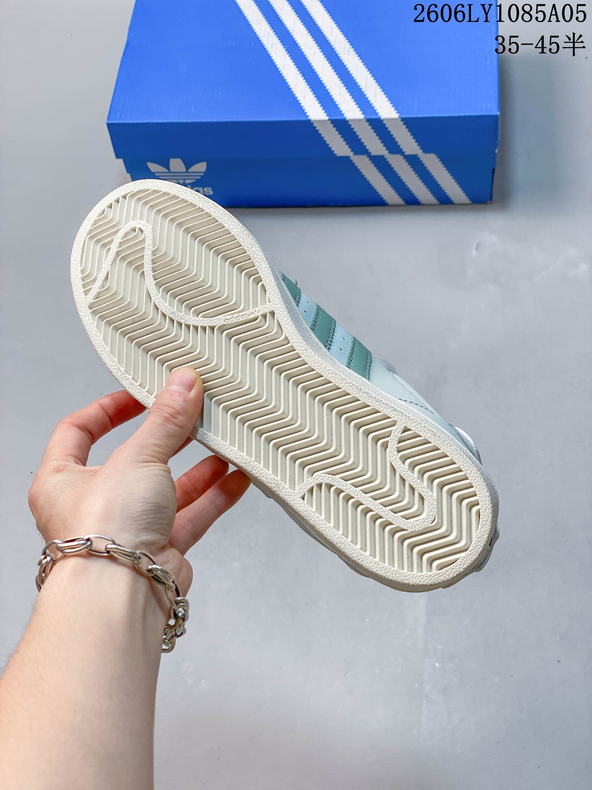 Underside of a Superstar sneaker showing the patterned cream-colored outsole.