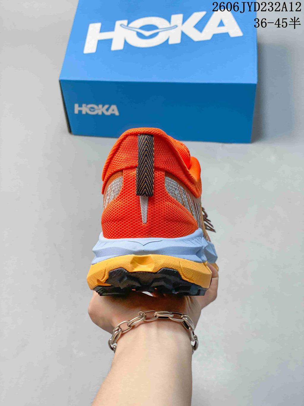 Rear view of the orange shoe with a contrasting midsole and outsole