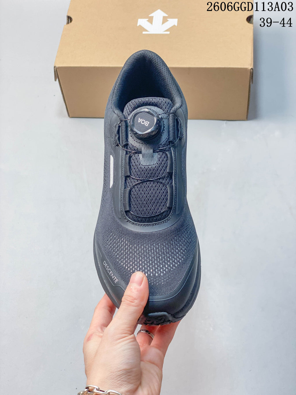 Top view of a gray DESCENTE shoe showing its dial closure and patterned upper