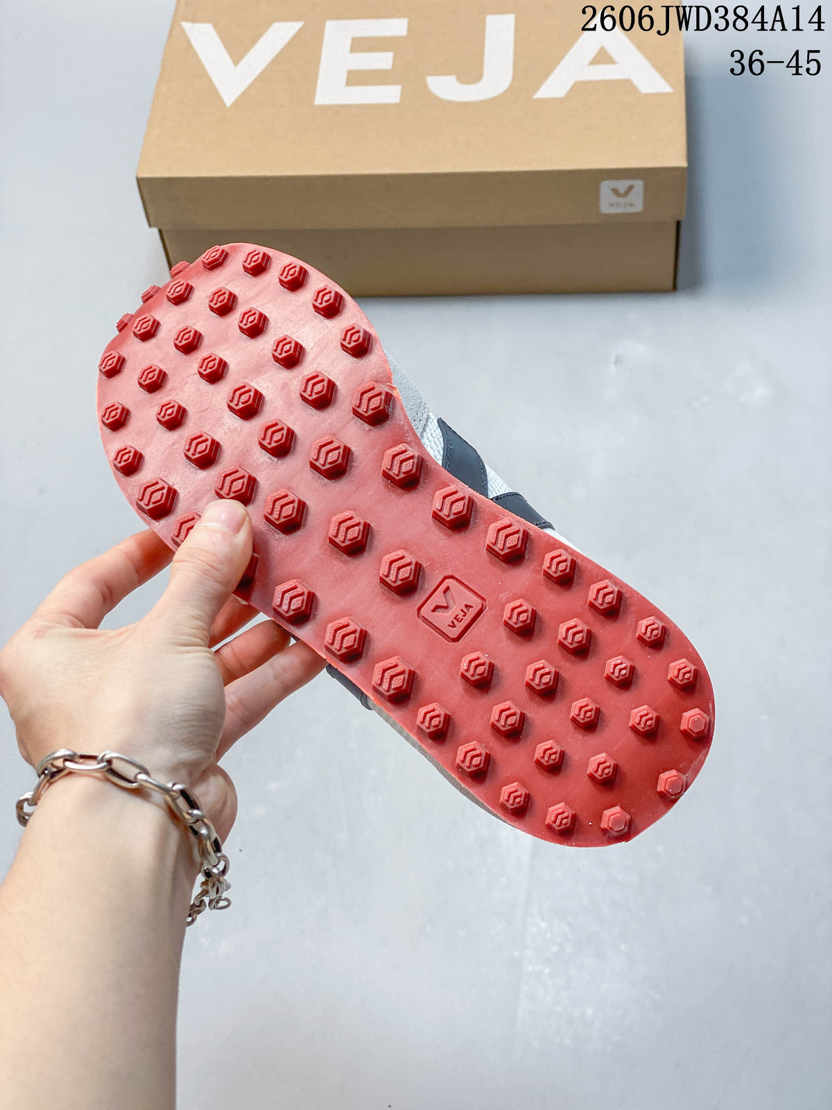 Red lugged outsole shown on a Veja sneaker beside a Veja shoe box