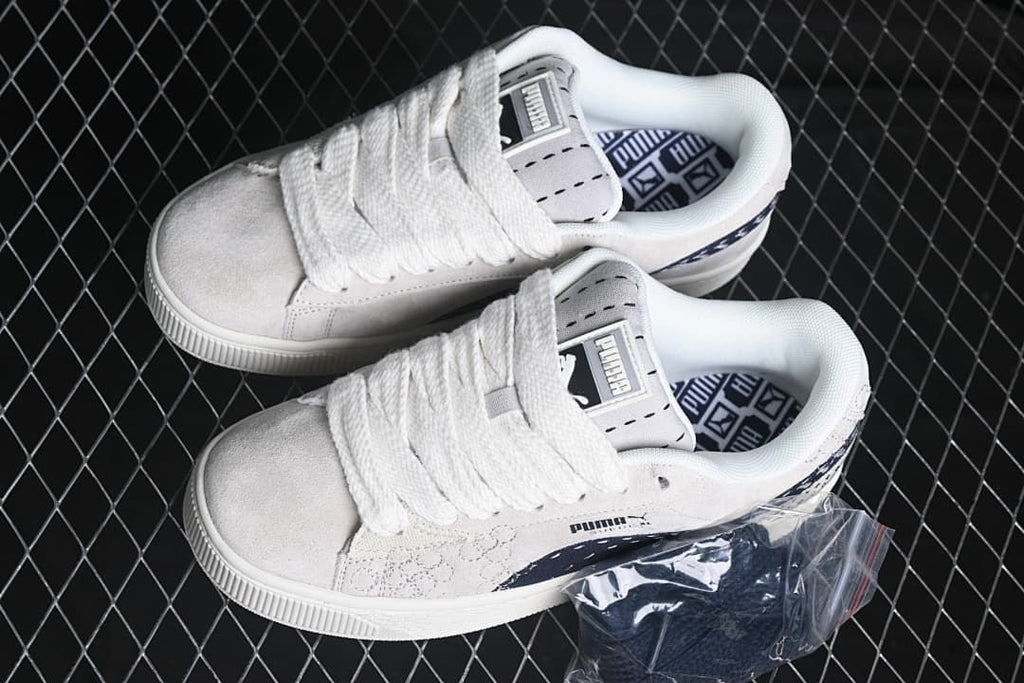 Pair of light-colored Puma Suede XL sneakers viewed from above.