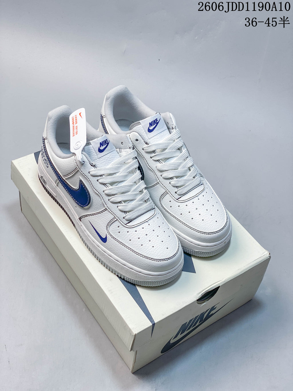 Pair of white low-top Nike Air Force 1 '07 sneakers with blue accents beside a shoe box
