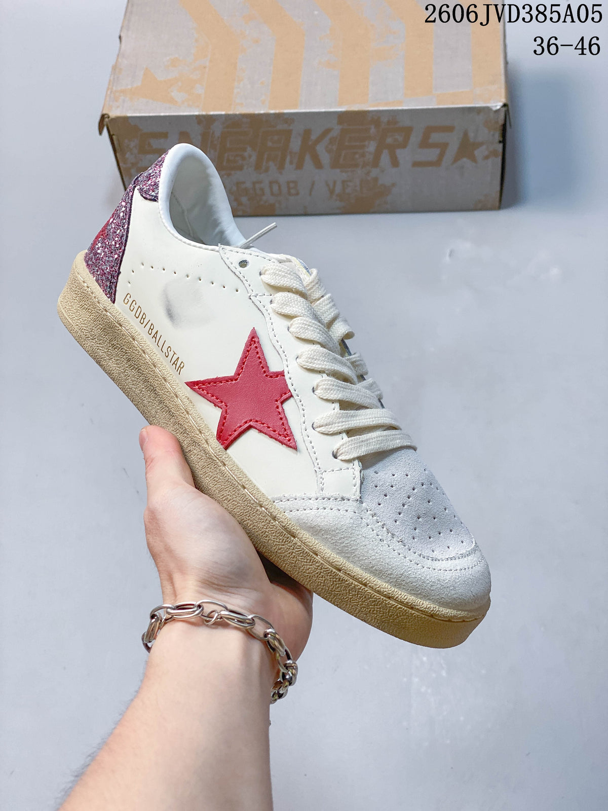 Angled side view of the white sneaker with a red star and glittery pink heel.