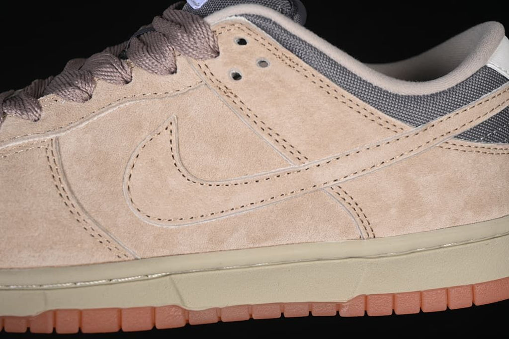 Close-up of beige overlays, tonal Swoosh, grey heel panel, and gum-colored outsole