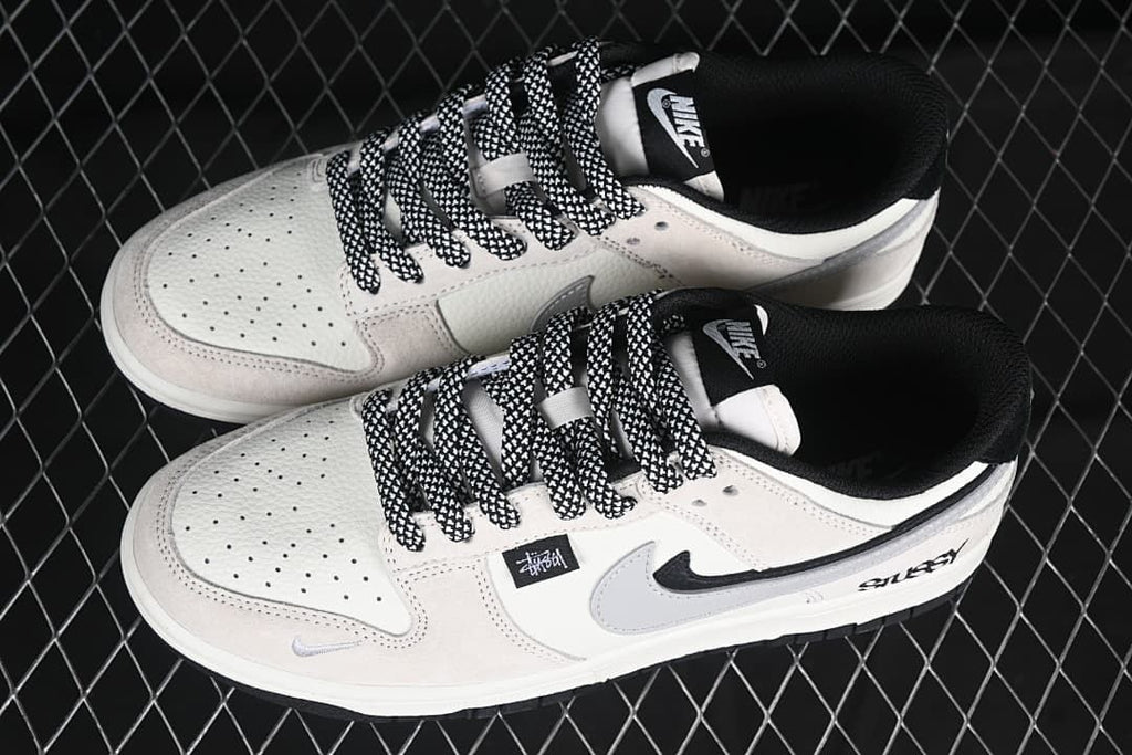 Pair of white and grey low-top sneakers with black-and-white patterned laces