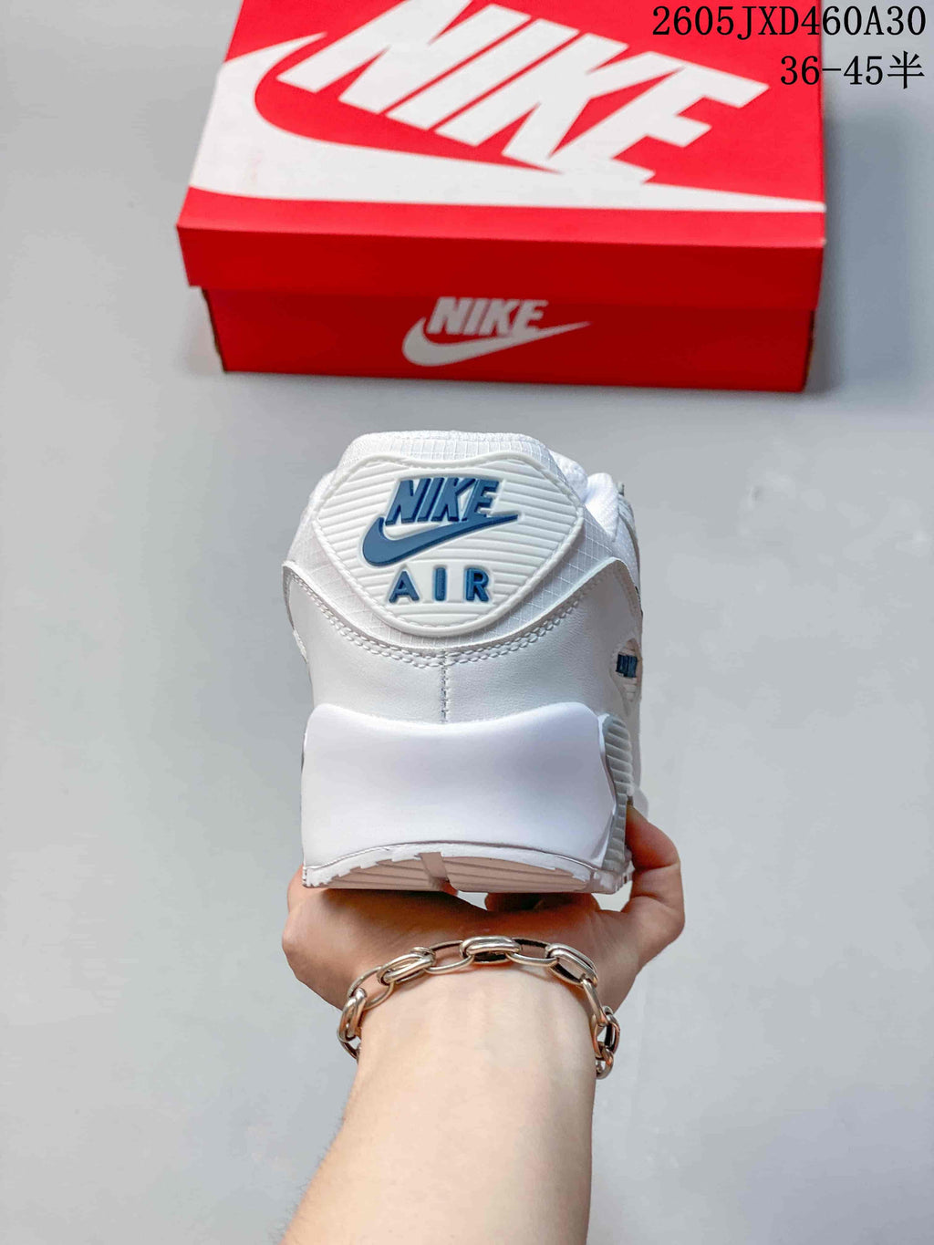 Rear view of a white Nike Air Max 90 sneaker showing the heel branding