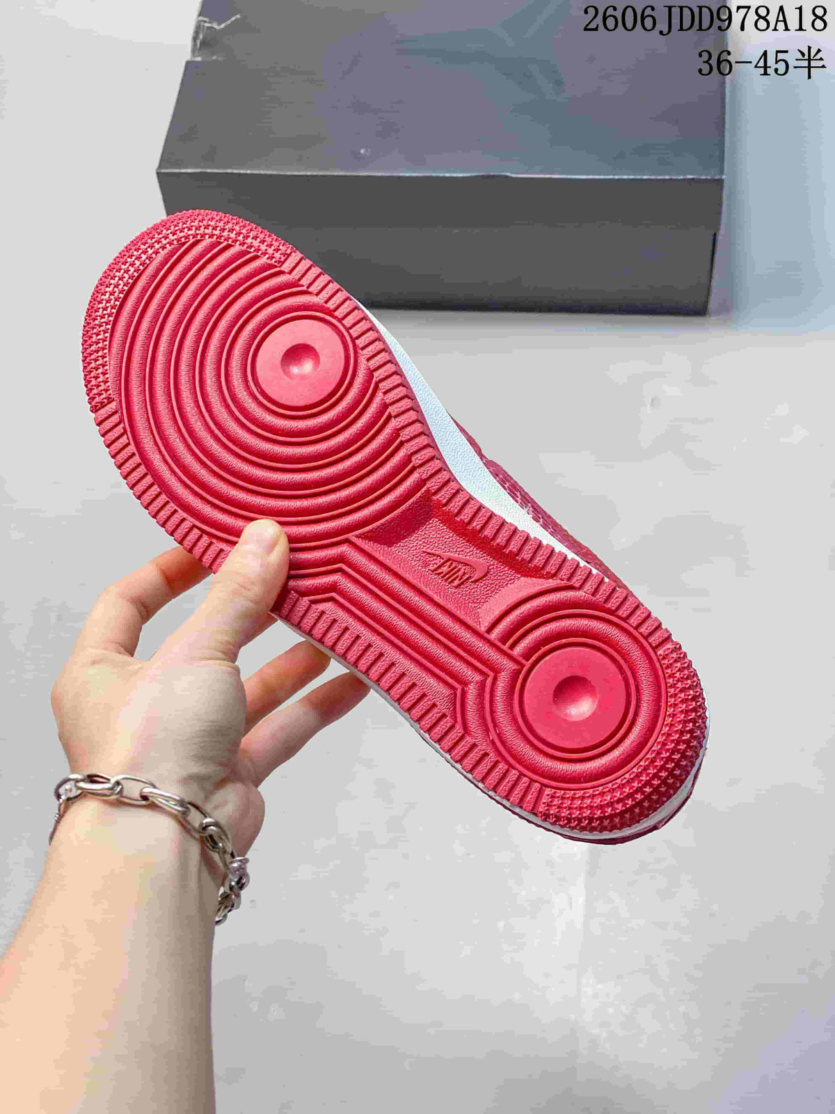 Red outsole of a patterned low-top sneaker showing circular tread details