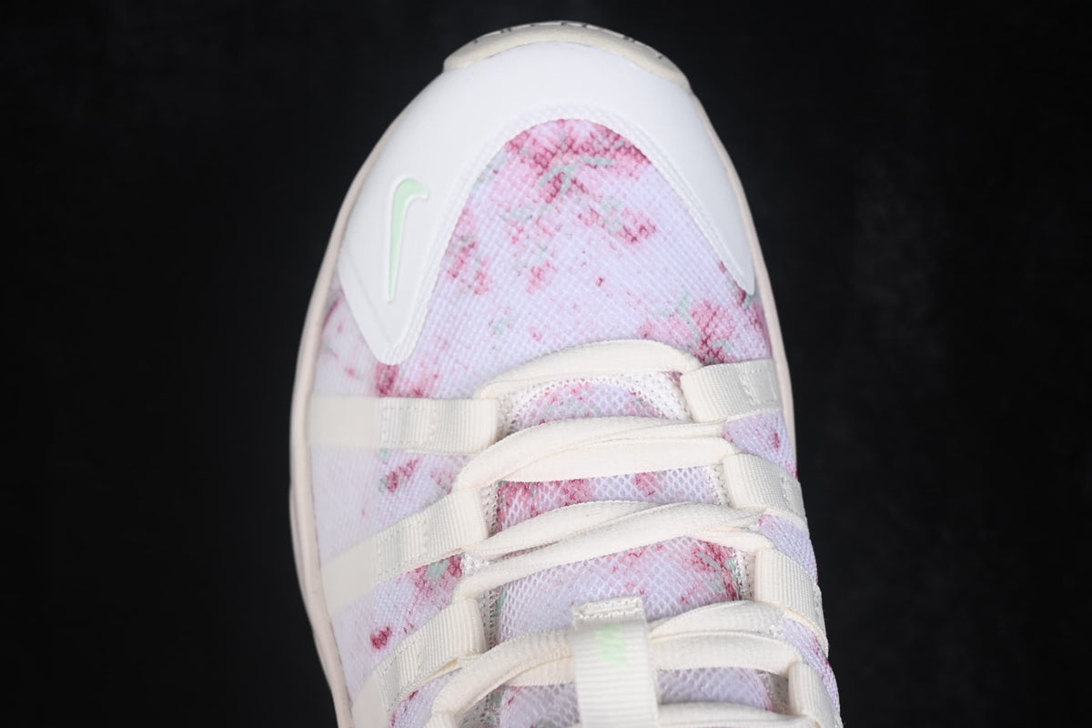 Top view of one sneaker showing the pink patterned mesh toe area, white toe overlay, and lace-up construction.
