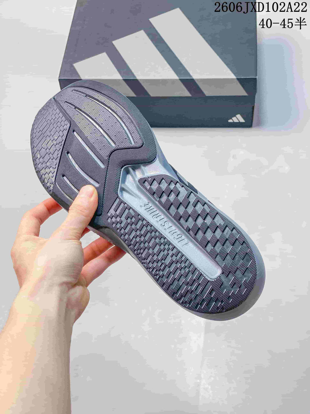 Close-up of the patterned outsole of a gray Adidas shoe