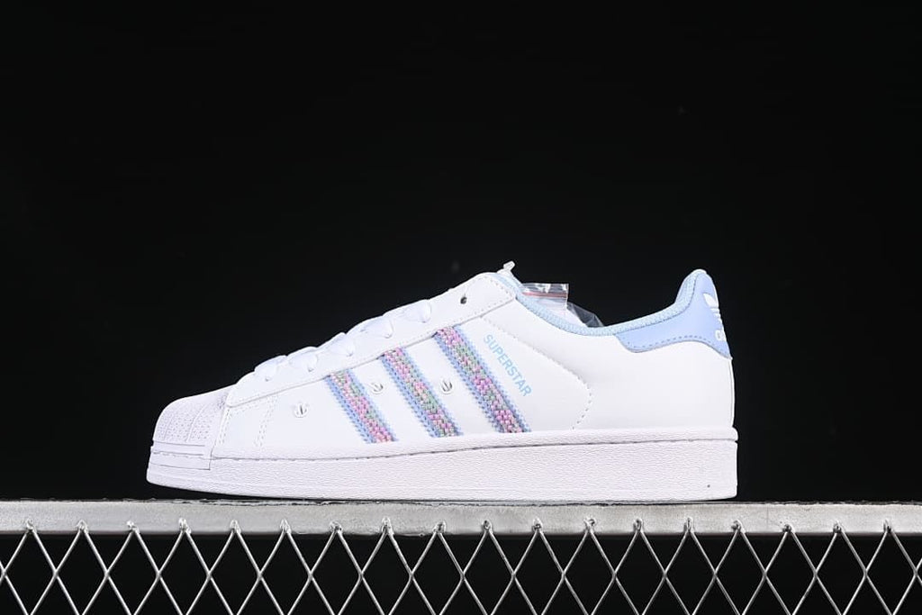 Side view of white adidas Superstar II sneakers with pastel stripes and light blue accents