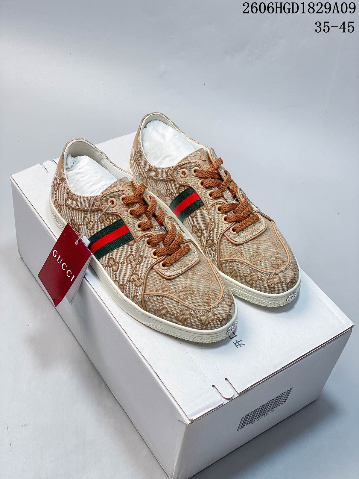 Pair of beige GG-pattern low-top sneakers with brown laces and green and red side stripes