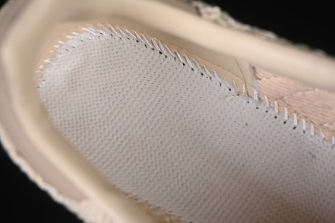 Close-up of the sneaker's woven side panel and stitched overlay