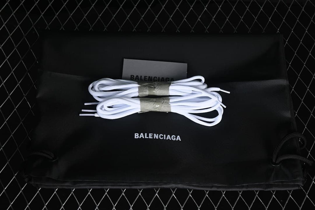 Black drawstring bag and extra white laces pictured with the sneakers
