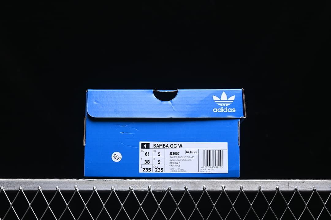 Shoe box label showing Samba OG W, model JI3907, and a photographed EU 38 sample size.