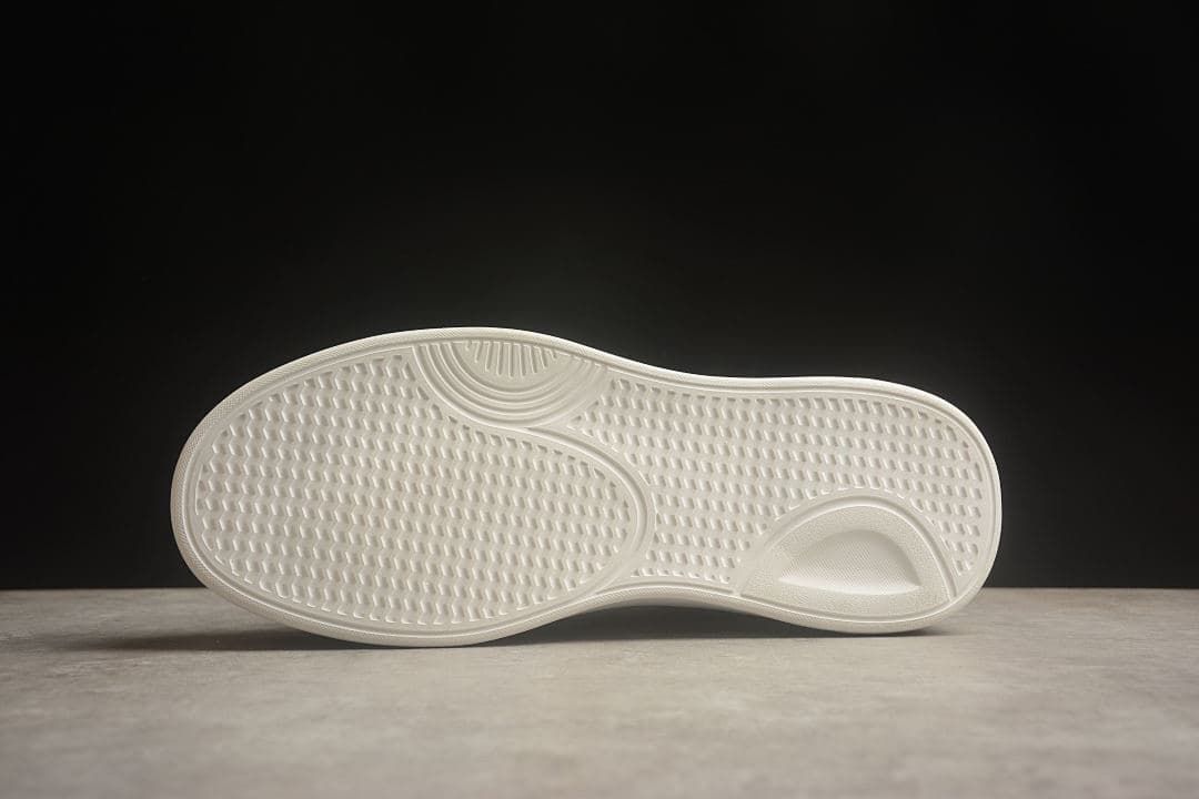 Underside of the sneaker showing the patterned white outsole