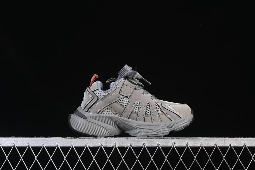 Side profile of one cement grey kids’ sneaker.