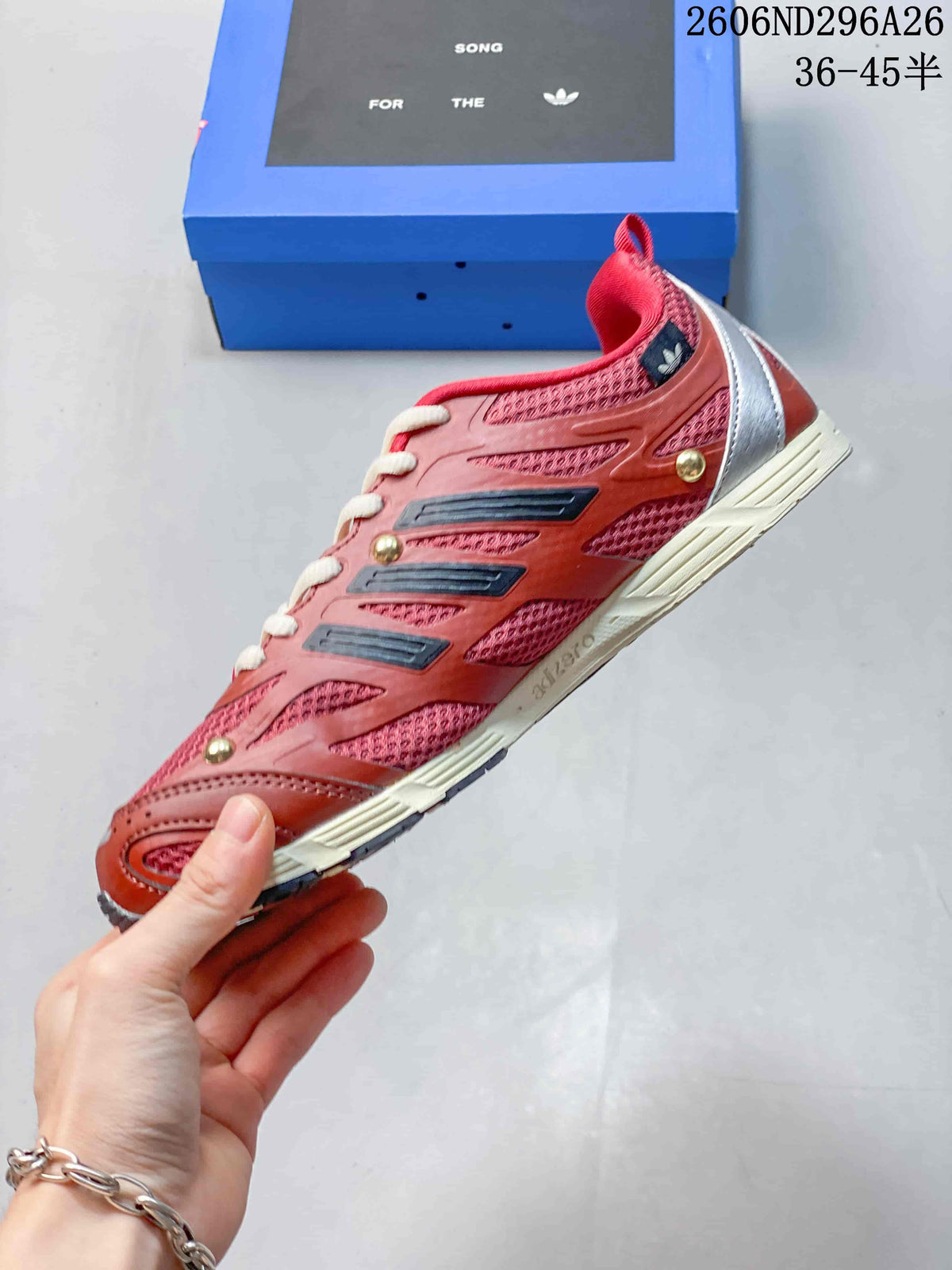 Side profile of a red low-top sneaker with contrasting overlays and cream sole