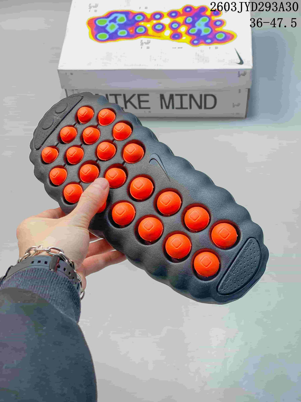 Underside of a Nike Mind slide showing raised orange outsole pods