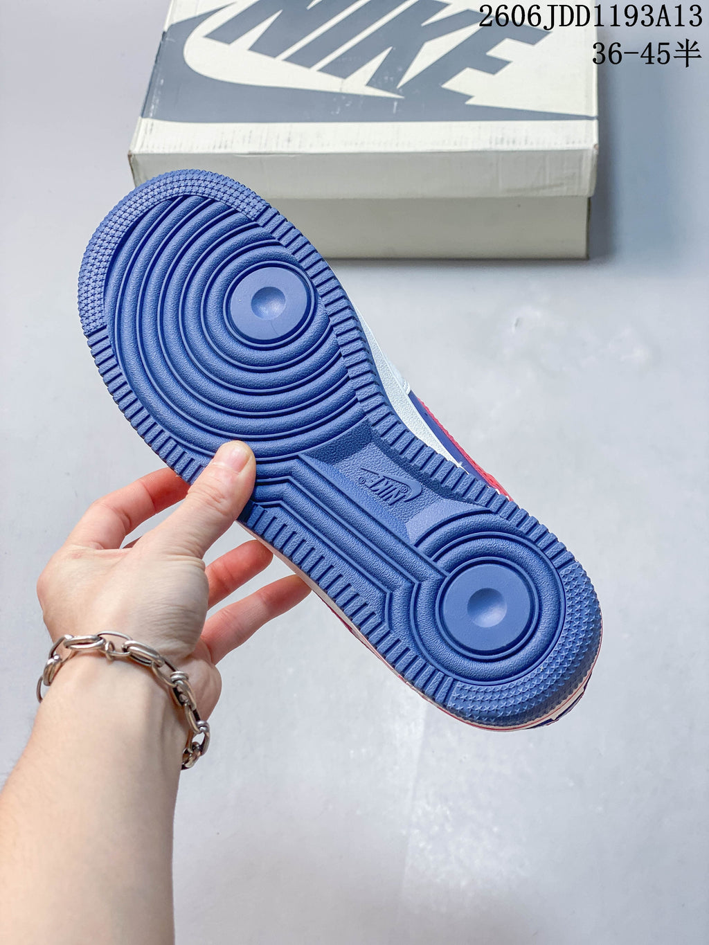 Blue outsole of the Nike Air Force 1 sneaker, with the shoe box in the background