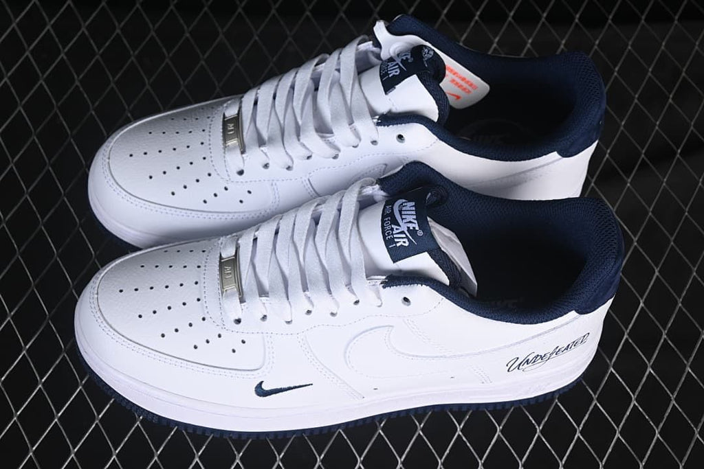 Pair of white and navy low-top sneakers shown from above