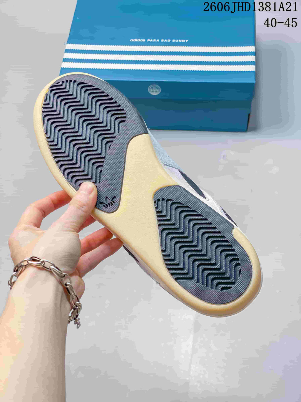 Close-up of the sneaker outsole with patterned tread and blue adidas-branded box