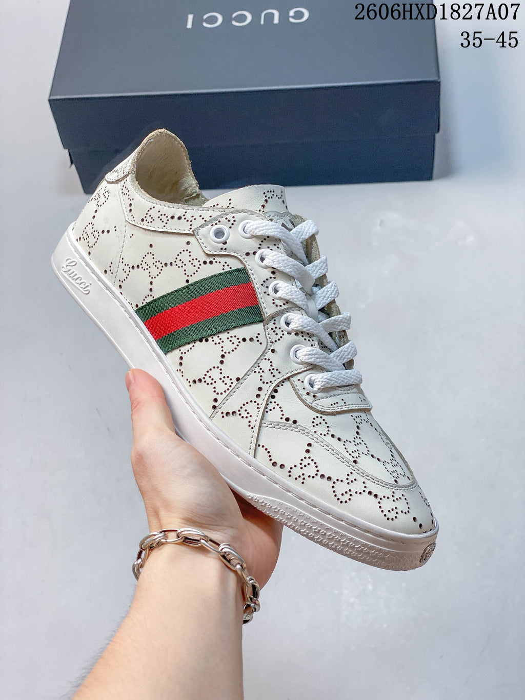 Angled view of white perforated sneaker with green-and-red stripe; image overlay shows size range 35–45 and style code 2606HXD1827A07