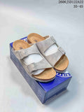 Pair of light taupe two-strap Boston-style clogs displayed on a blue box.