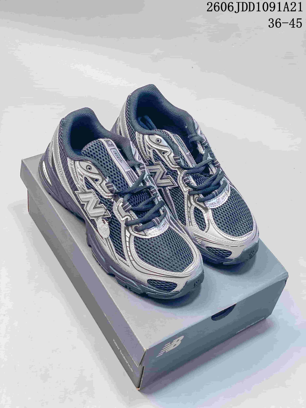 Pair of dark navy and silver-toned New Balance 740 sneakers on a shoebox