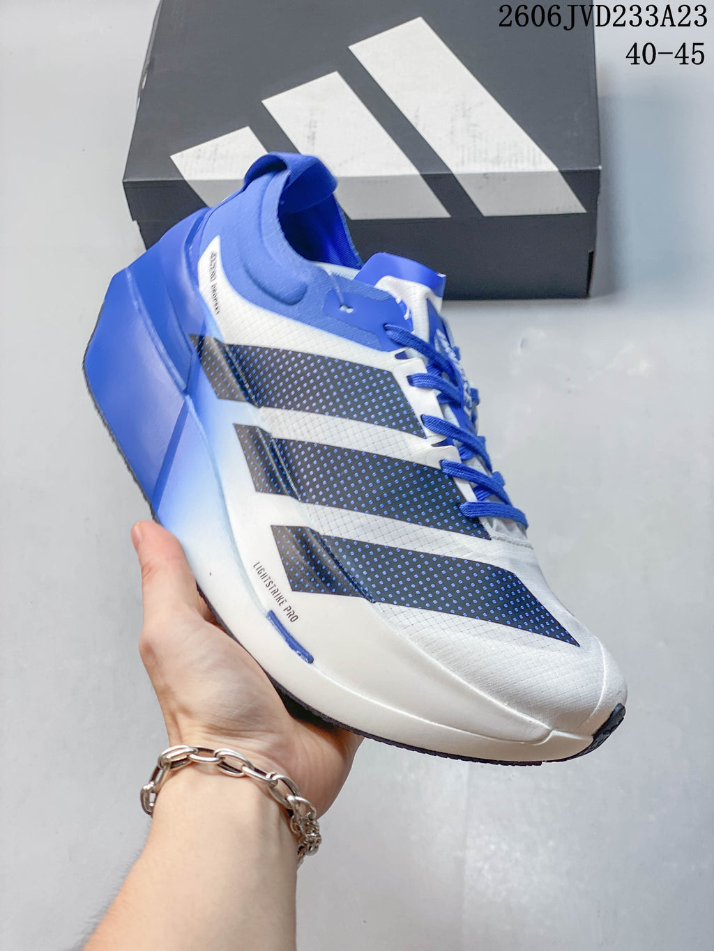 Blue and white Adidas Adizero Prime X3 running shoe shown from the side.