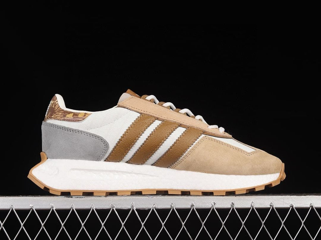 Outer side view showing brown stripes, gray heel panel, and white midsole
