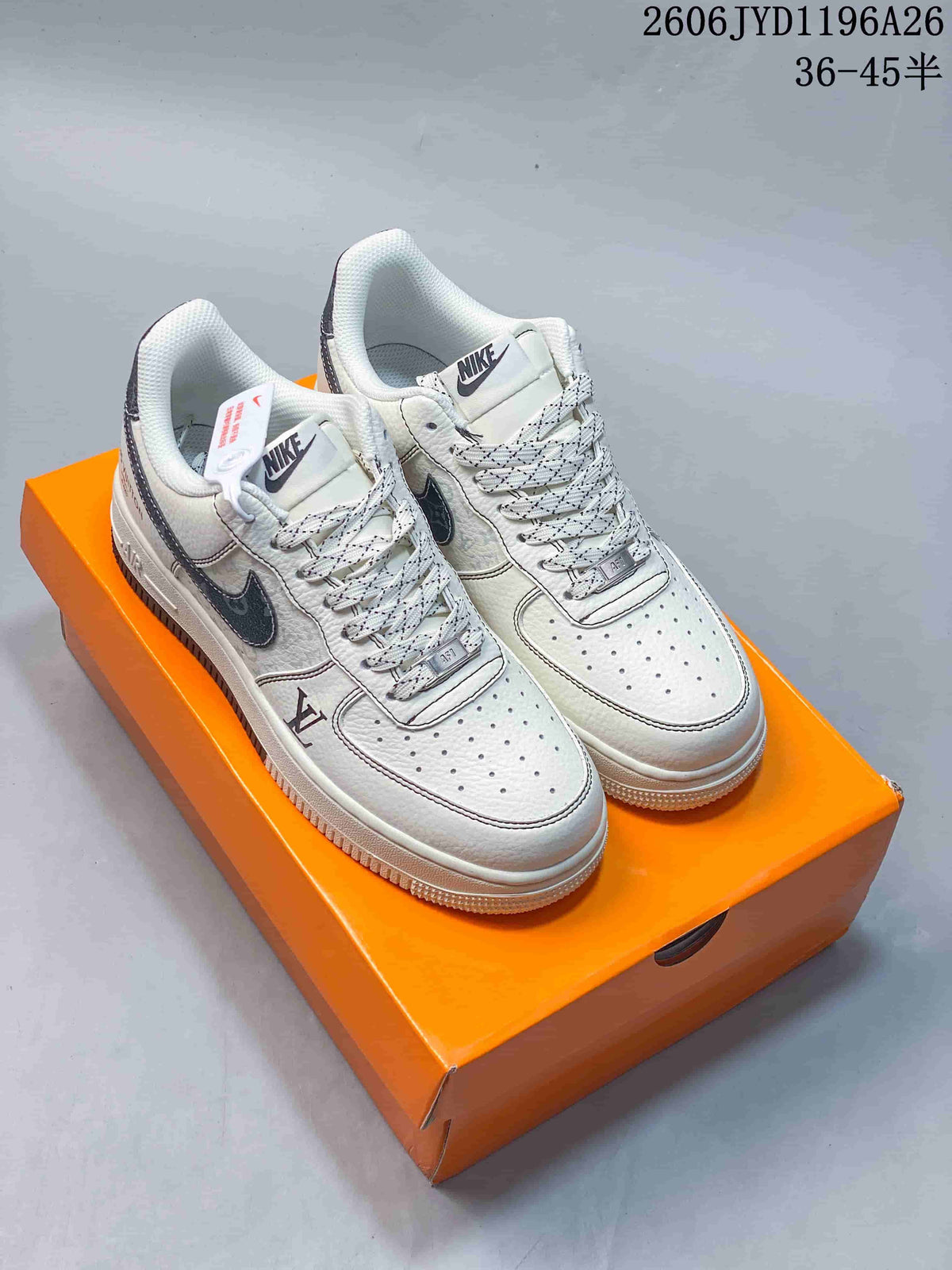 Pair of white low-top sneakers with dark side details and patterned laces.