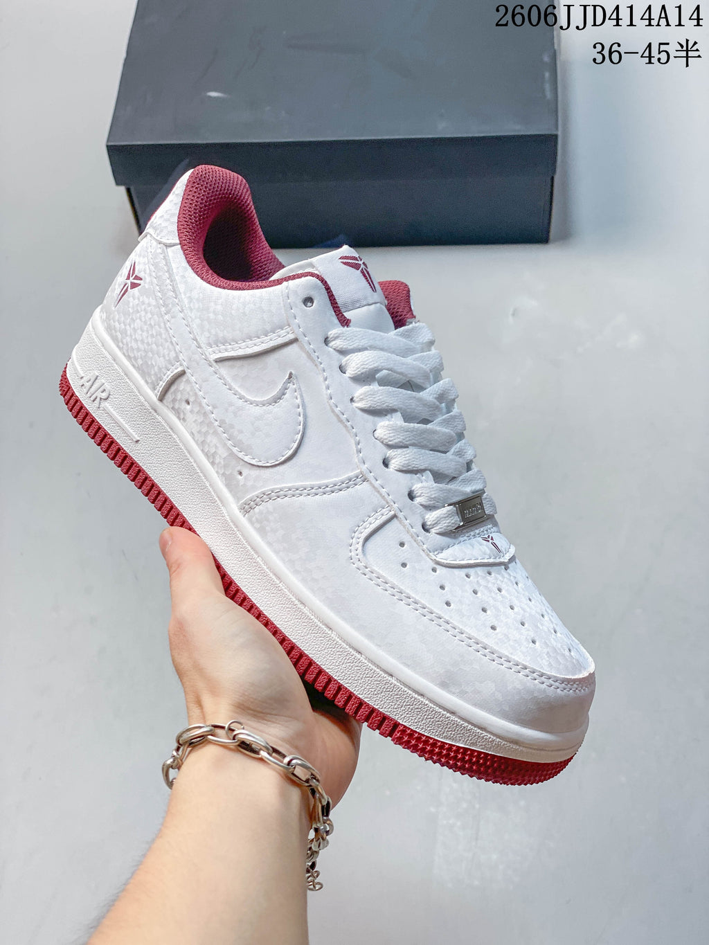 Side view of a white low-top sneaker with red outsole and collar details
