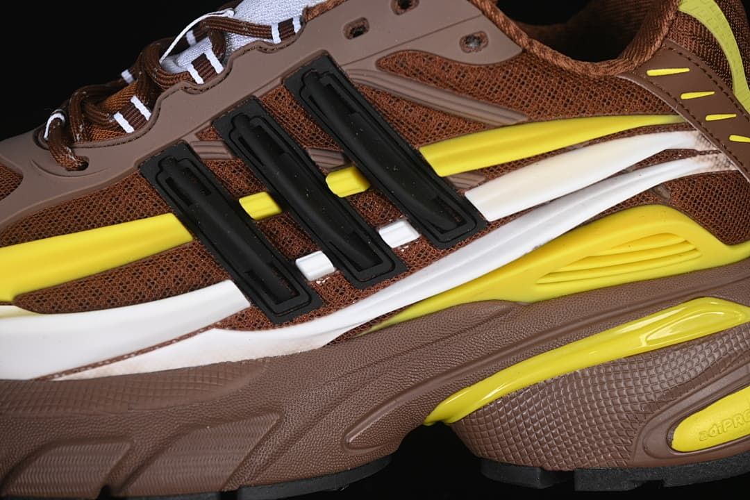 Close-up of the brown mesh upper, black side details, and yellow and white overlays