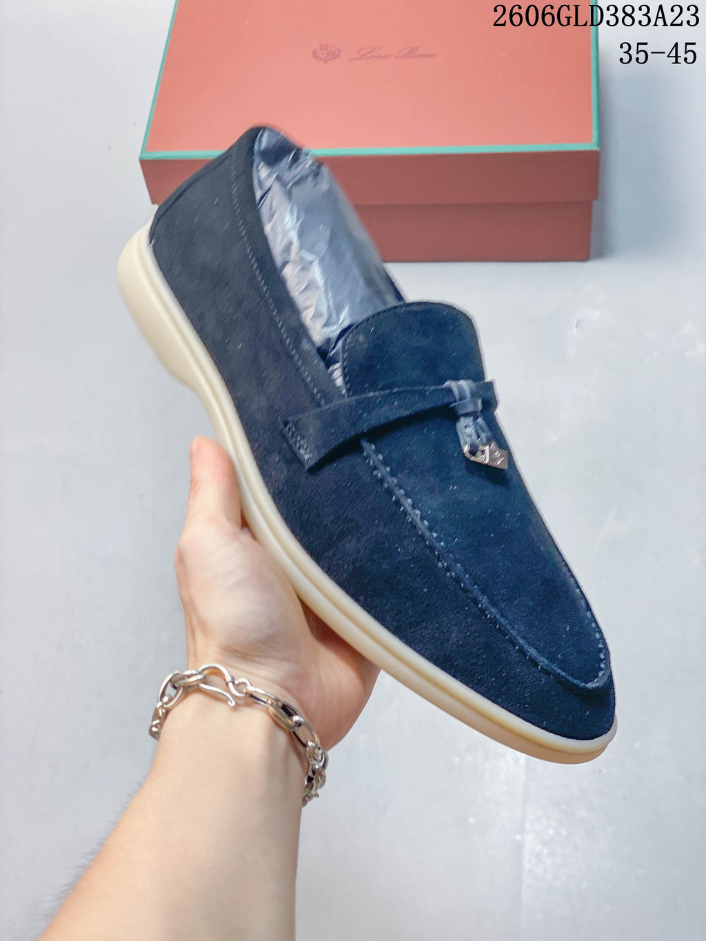 Angled view of a navy loafer with a rounded toe and vamp strap