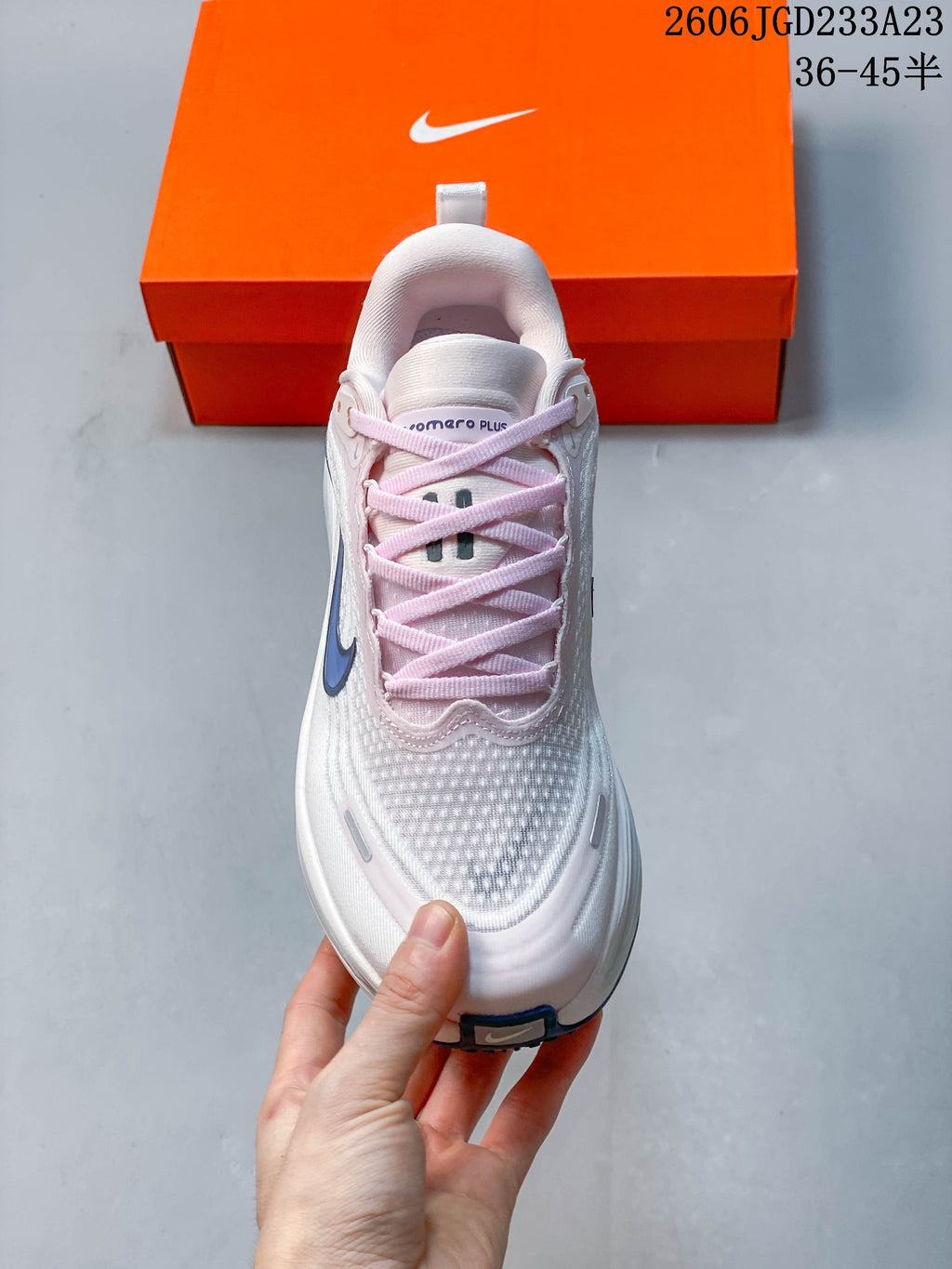Front view showing the textured upper and pale pink laces of the Nike Vomero Plus.