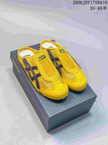 Pair of yellow Onitsuka Tiger Mexico 66 Sabot slip-on sneakers with dark side stripes, shown on a shoebox