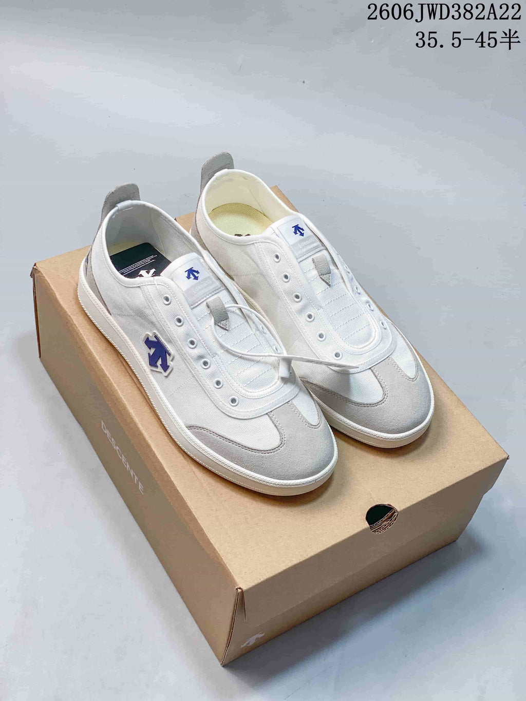 White and light grey DESCENTE Chron Pacer CVS sneakers displayed on a branded box