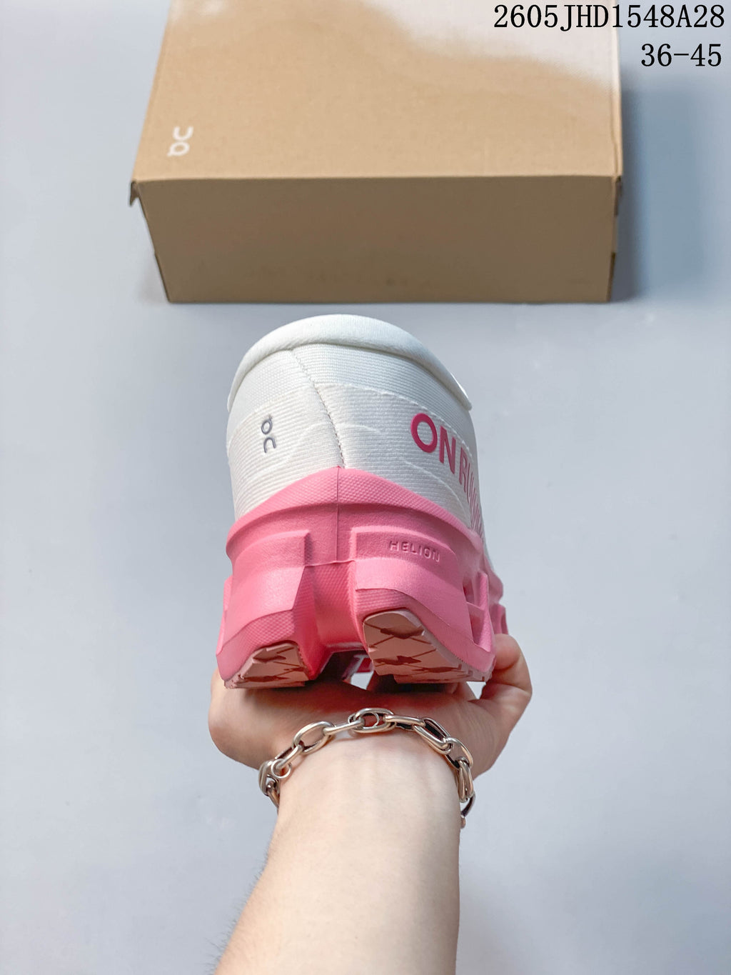 Rear view of the white shoe with a pink sole and heel branding