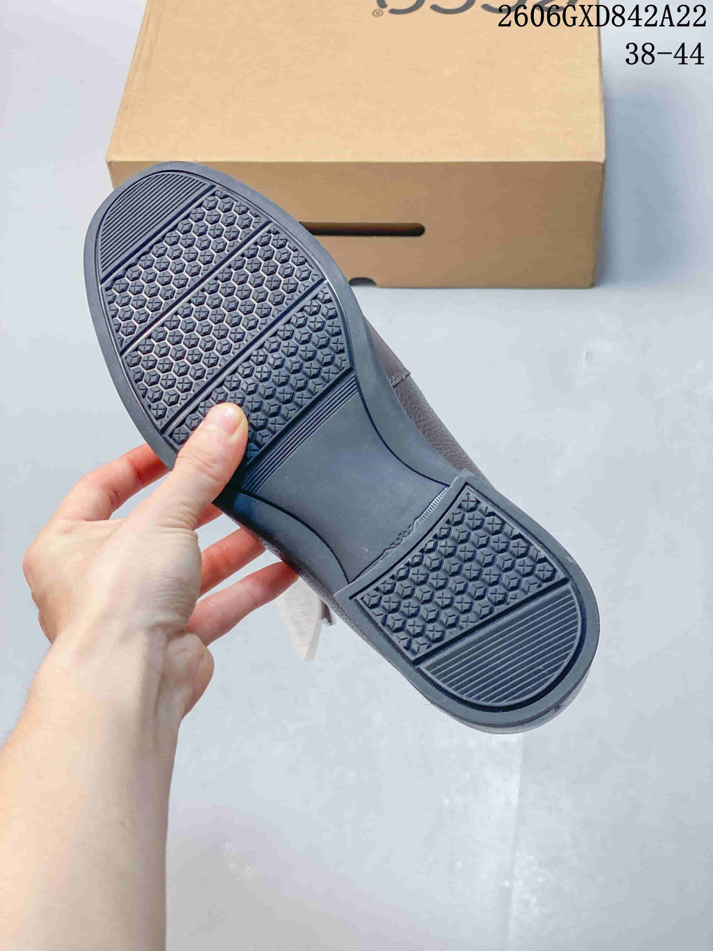Underside of a loafer showing a dark patterned outsole