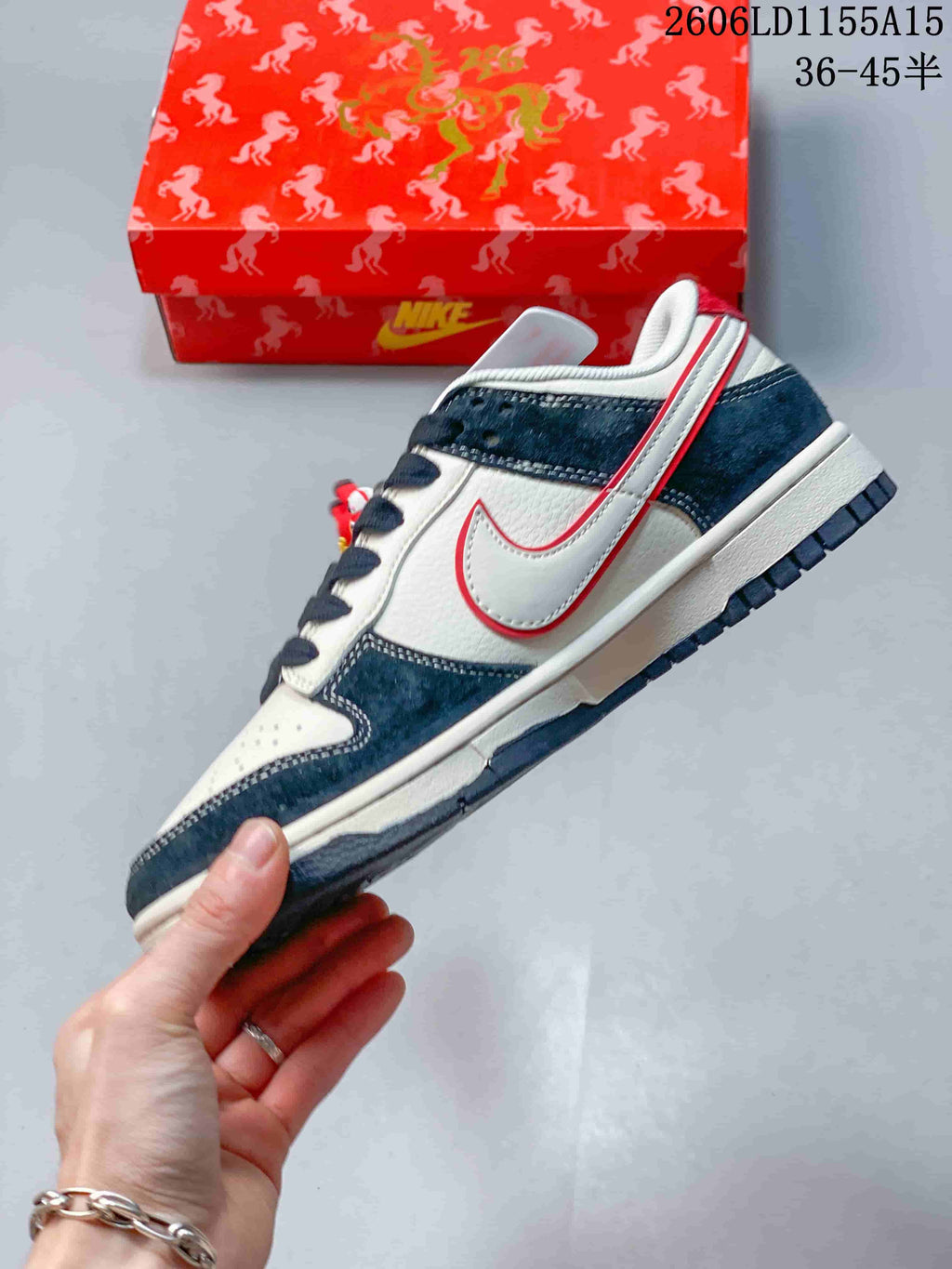 Side profile of an off-white and navy low-top sneaker with a red-edged swoosh