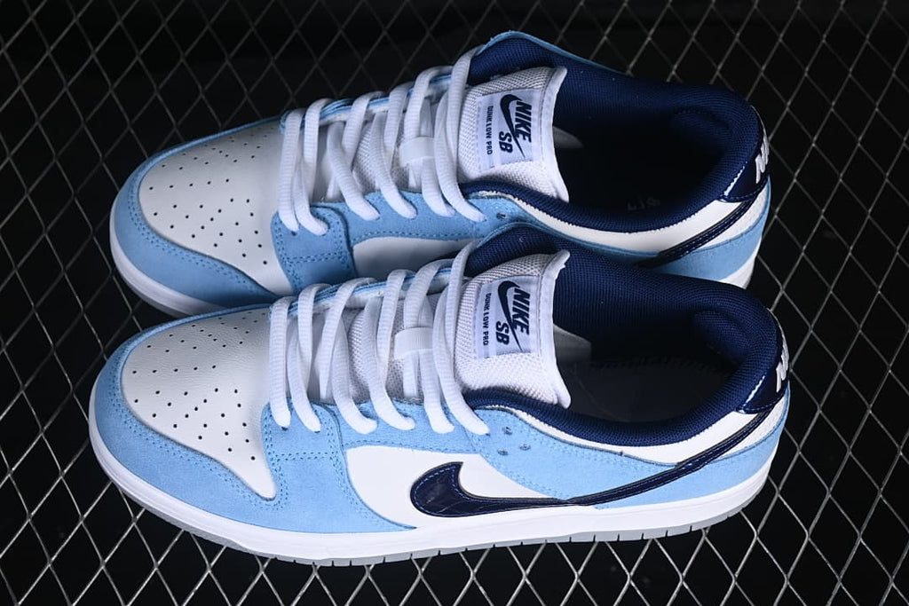 Pair of white, light-blue and navy Nike SB Dunk Low-style sneakers viewed from above.