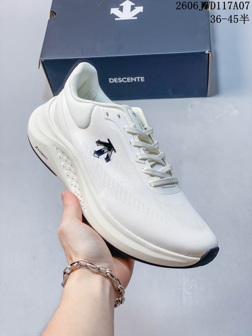 Angled side view of a white DESCENTE RUN STEP shoe with dark logo and outsole accents