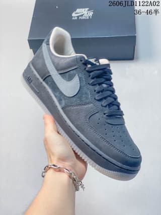 Close-up side view of a black Nike Air Force 1 sneaker showing the Swoosh, perforated toe box, and padded collar.