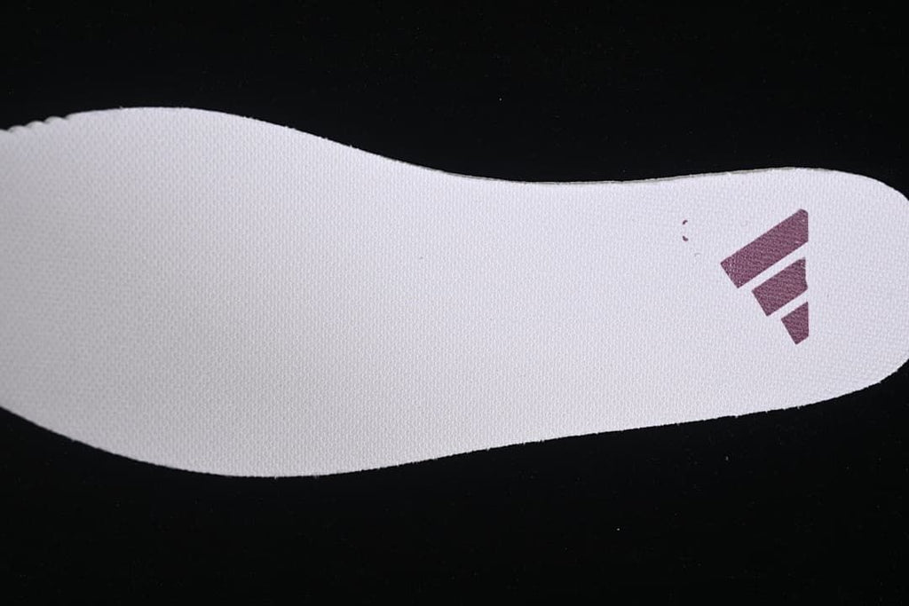 Light-colored shoe insert with a purple adidas logo